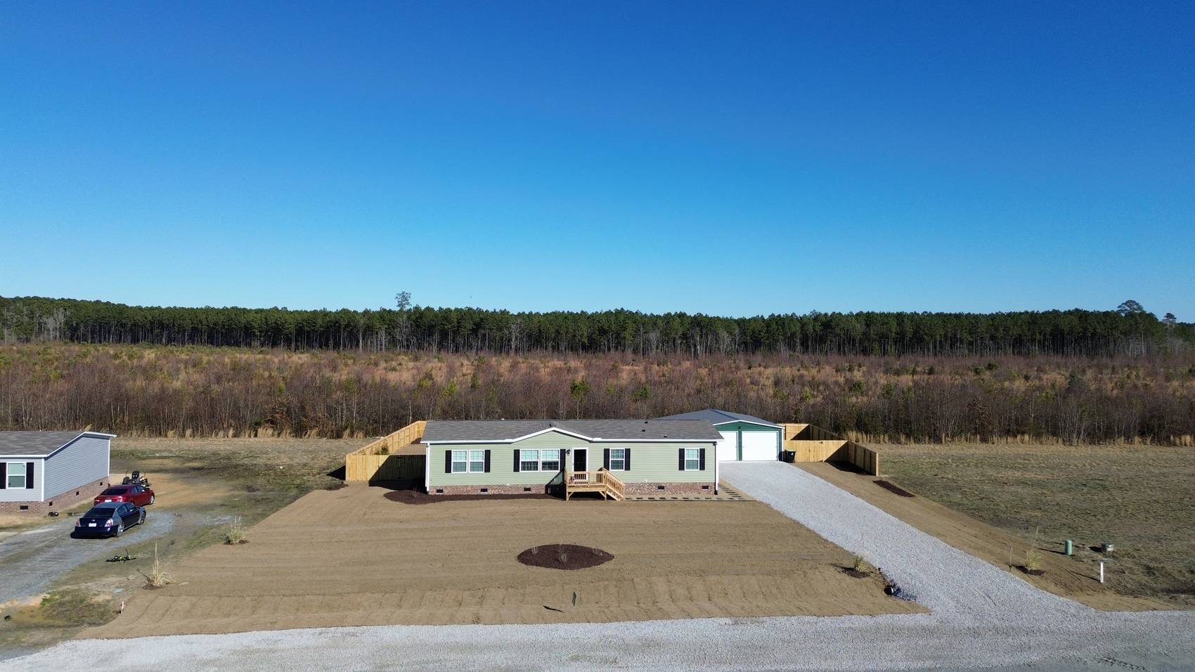 Aerial view of a graded home site with new gravel driveway