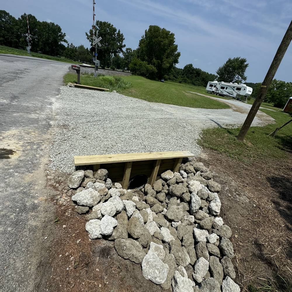 Culvert crossing with riprap stone apron at a gravel driveway