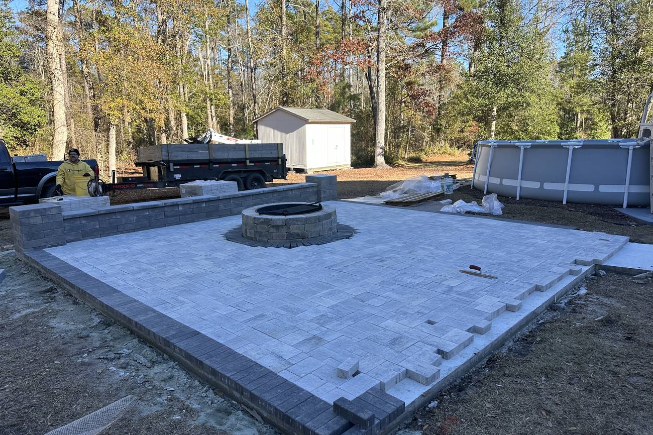 Paver patio under construction showing the compacted base and edge before stone is set