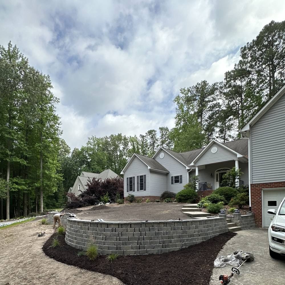 Curved segmental block retaining wall with mulched beds